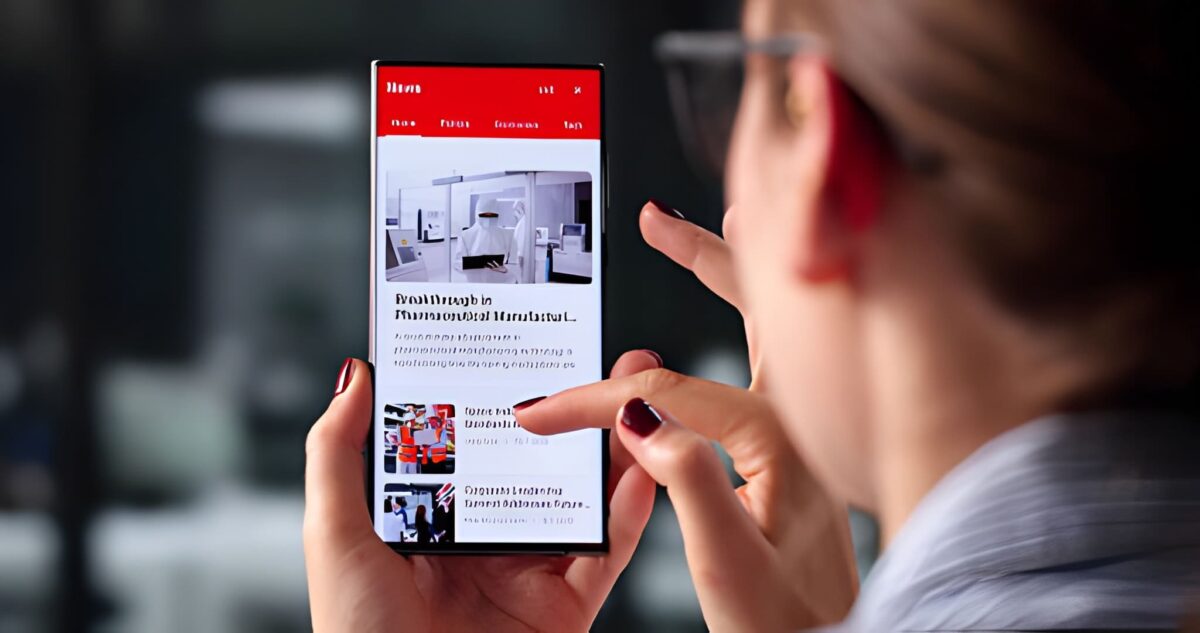 Woman Browsing Online News Headlines On Phone In Office Break