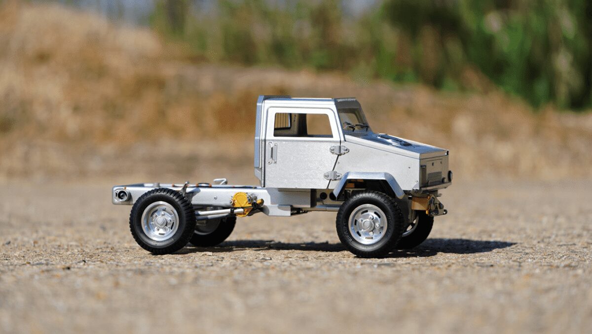 Rear section of a Toyota vehicle with beige steel wheels, off-road tires, and a beige rear bumper with black and orange accents.