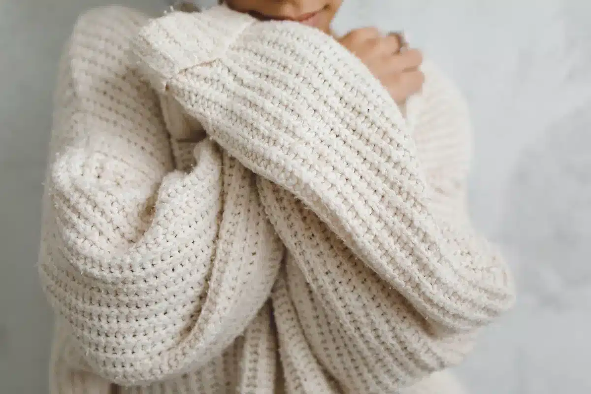 Frau tr&auml;gt Strickballettflats mit Jeans und &uuml;bergro&szlig;em Pullover