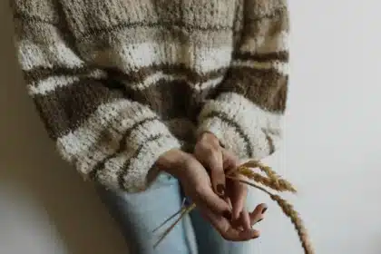 Knit ballet flats paired with denim and oversized sweater on neutral surface