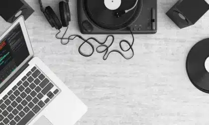 Vinyl record playing in a dimly lit recording studio with vintage tape reels and analog equipment