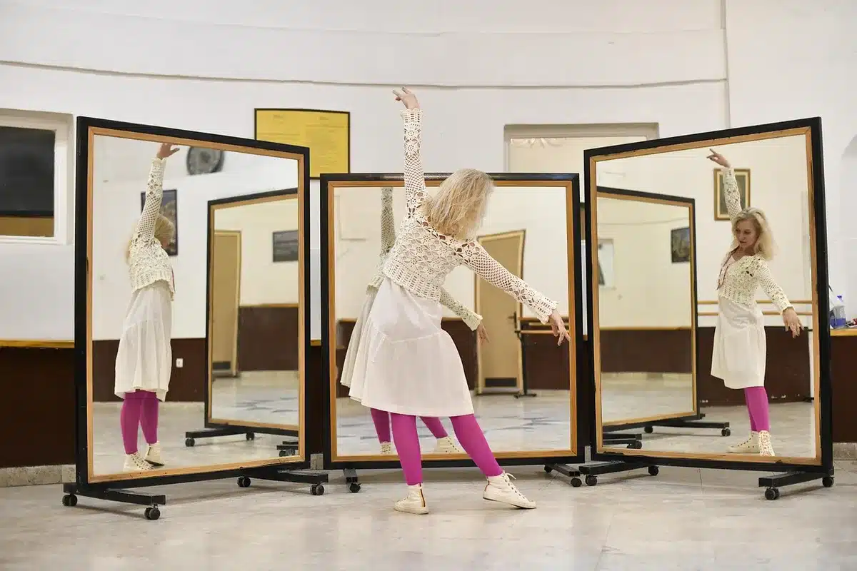 Two dancers practicing in a rehearsal studio with one coaching the other