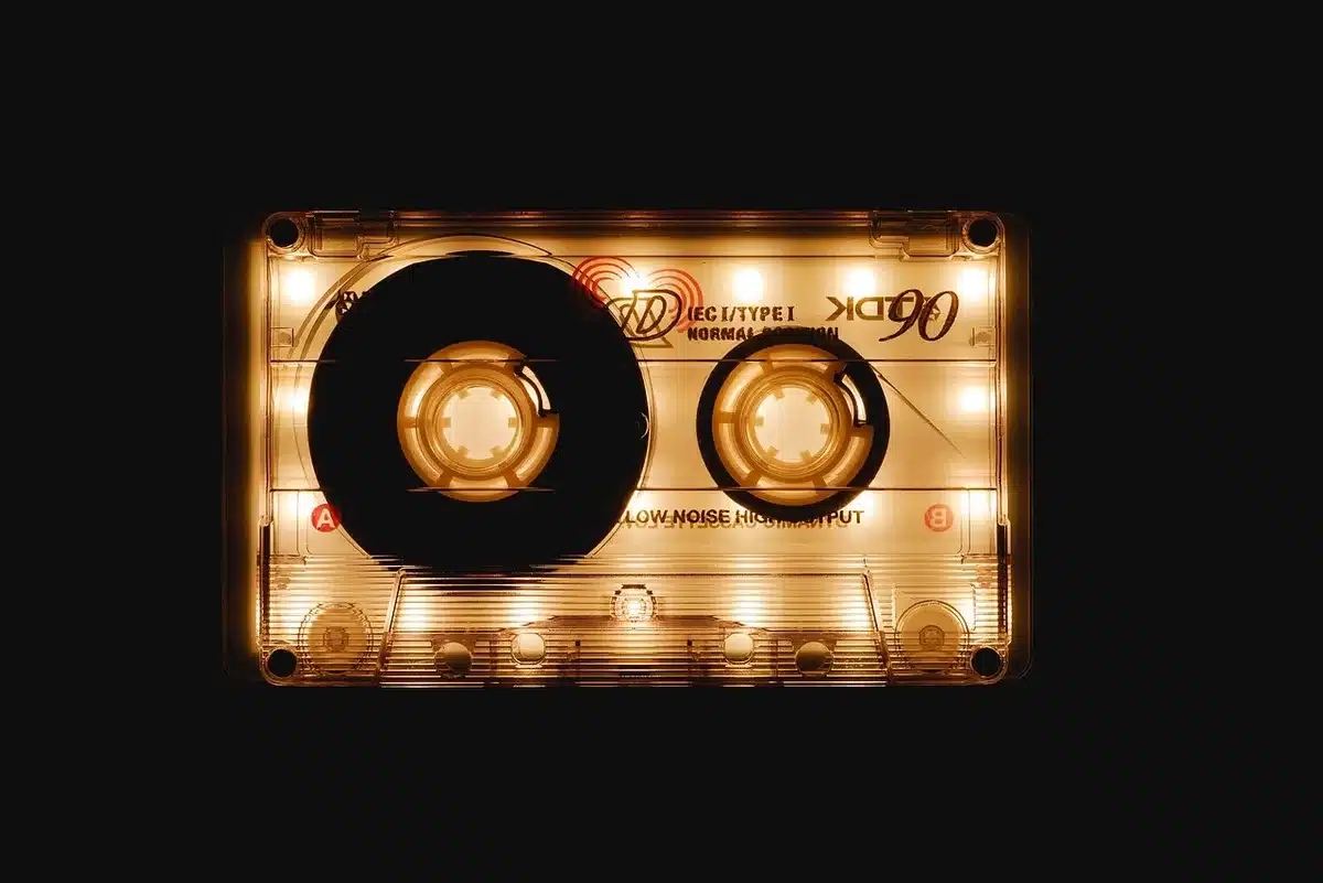 Hands near a vintage tape deck and marimba on a sunlit wooden table