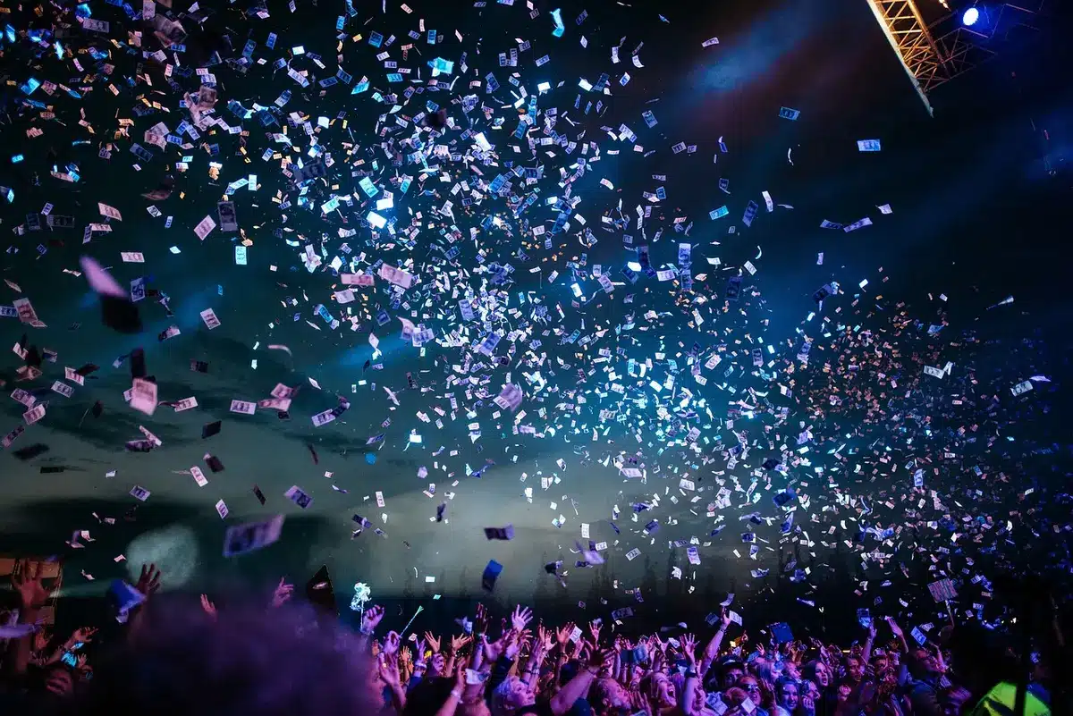 Anonymous audience figures approaching a stage during a comedy show