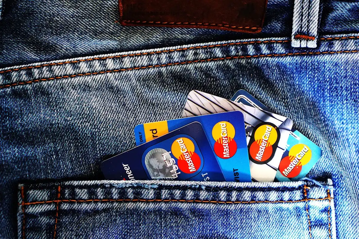 Two people laughing while one mockingly shows an open wallet