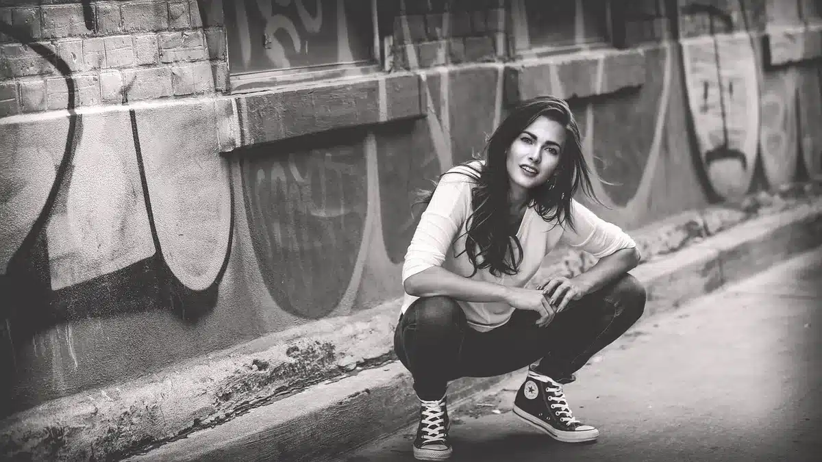 Anonymous figure holding Reebok sneakers on a studio set, campaign props blurred