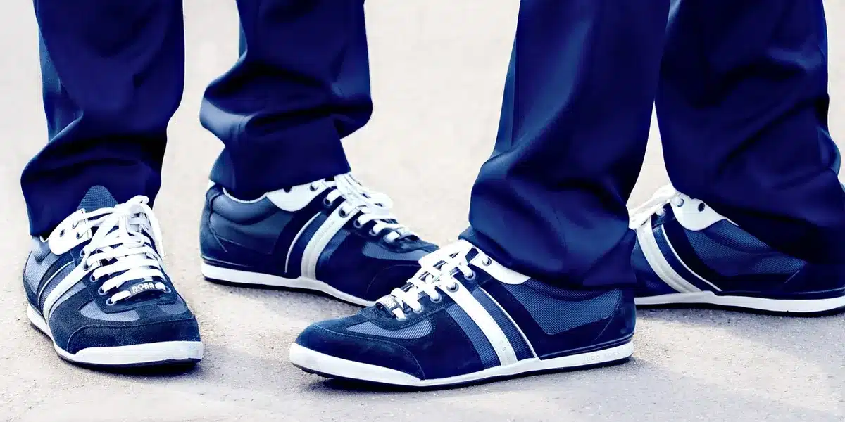 Club C style low-top sneakers paired with relaxed denim on wooden floor