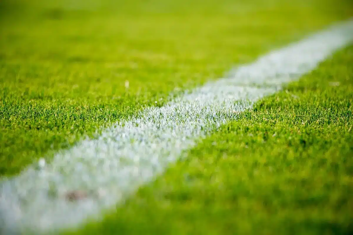 Player lying on turf being assessed by medical staff after a tackle