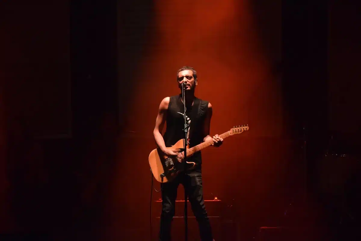 Guitar and synth layered in a studio setting evoking widescreen rock