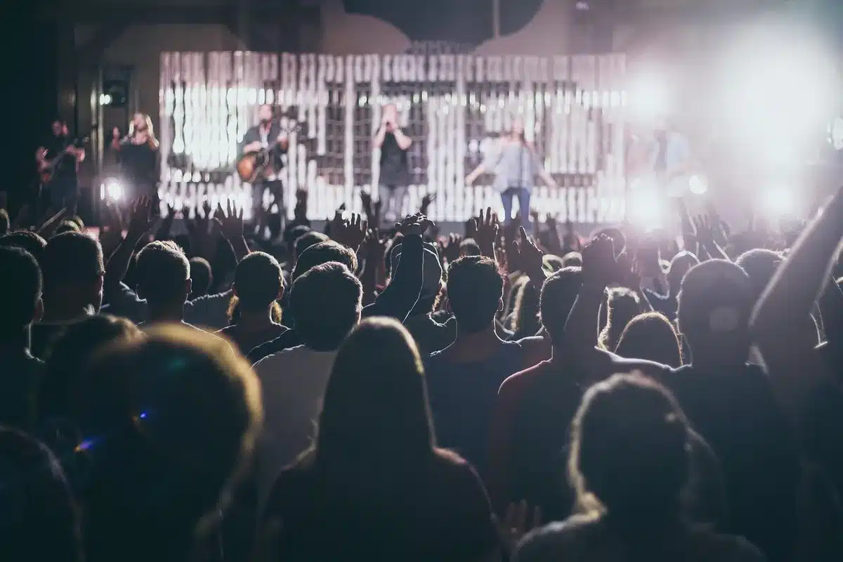 Band performing live to a small attentive crowd with stage lights