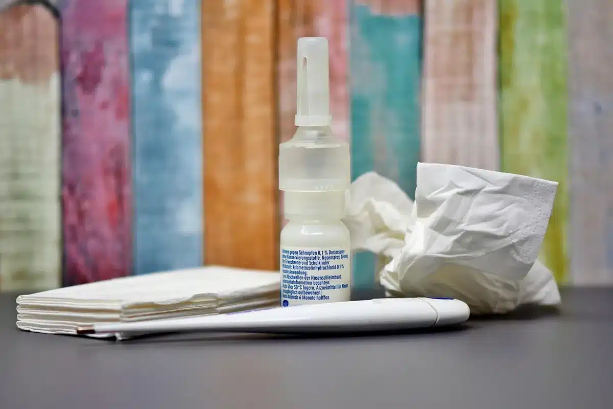 Thermometer and pediatric dosing guide next to medicine cabinet items
