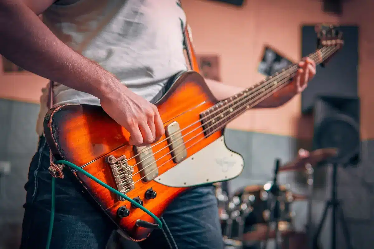 Vintage bass guitar on a rehearsal floor evoking early bands and musical rise