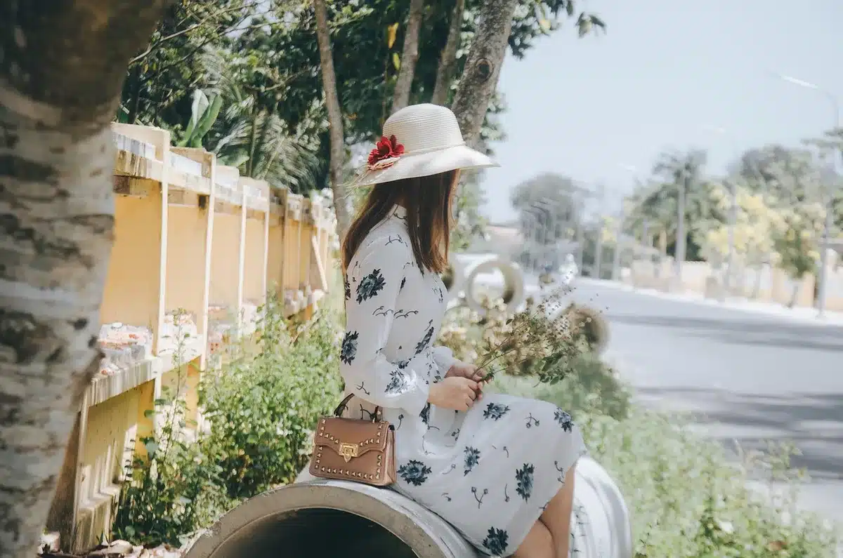 Street-style shot of a pale slip midi dress worn by an anonymous person