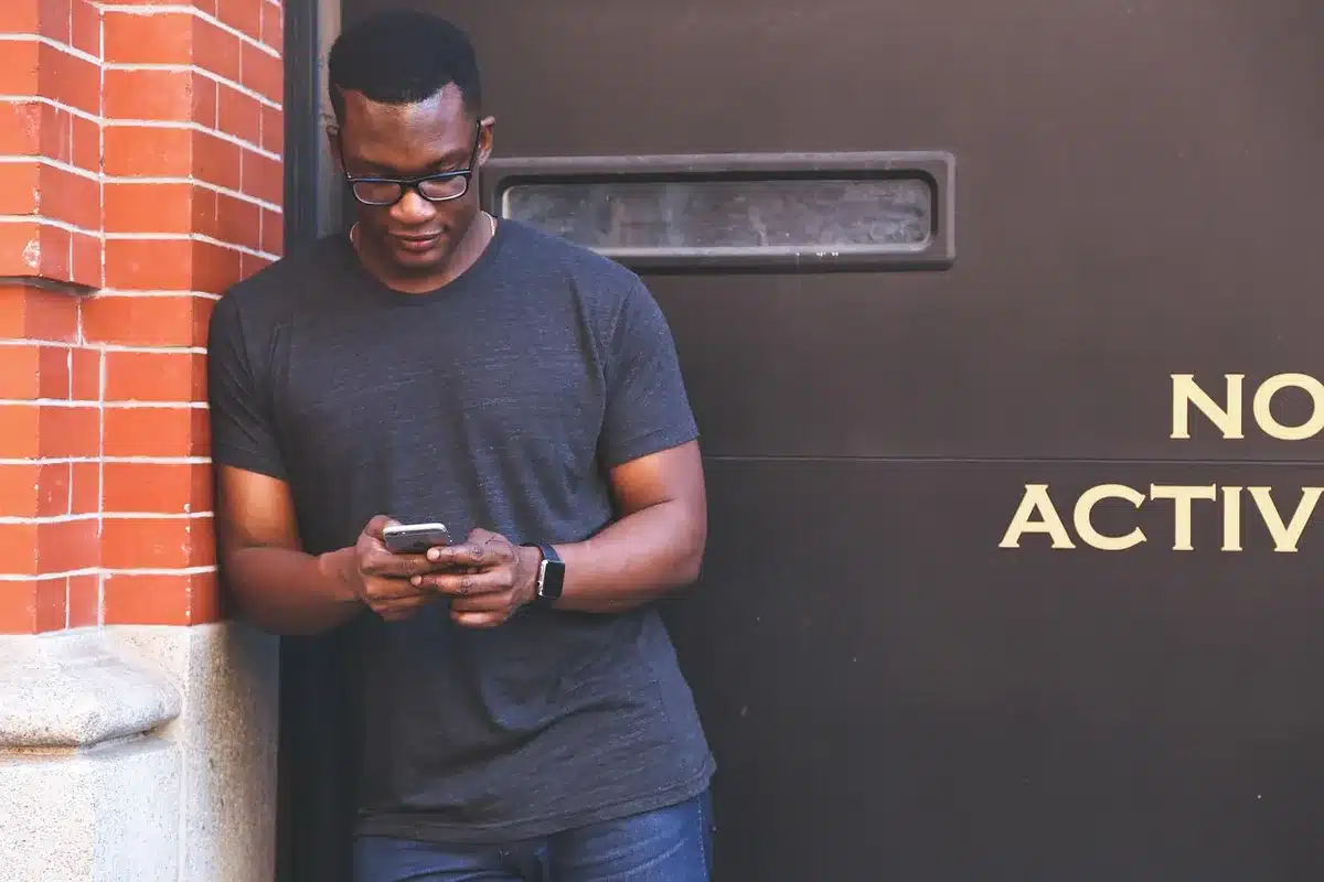 Person looking at social media comments on a phone, illuminated by screen
