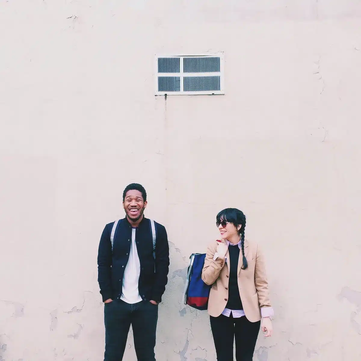 Hands holding a phone showing a social media reel of a laughing couple