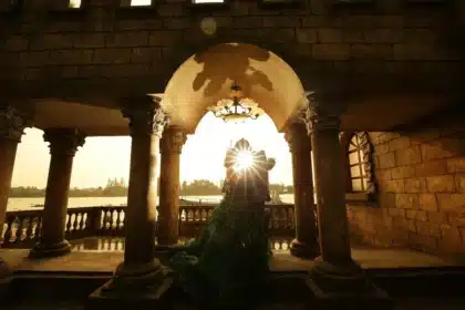 Silhouette of a couple on a hotel balcony with scattered photos and a phone