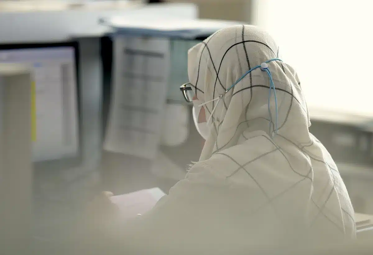 Woman at a nonprofit office desk looking reflective