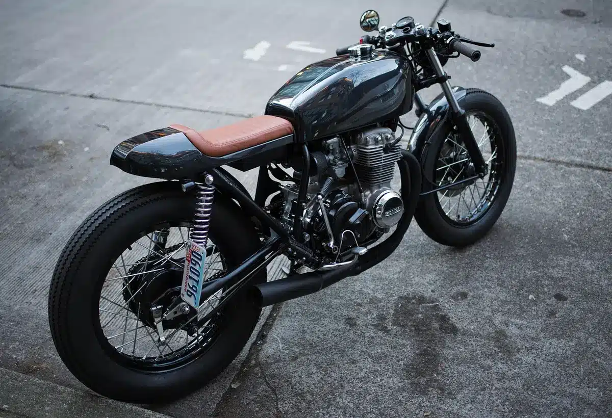 A motorbike rolling down a narrow street at dusk as seen in a short teaser clip