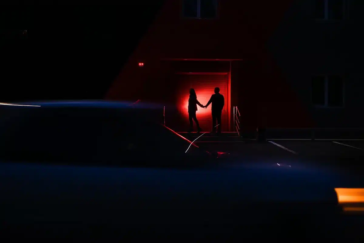 Silhouette in a dim bedroom doorway suggesting a tense encounter