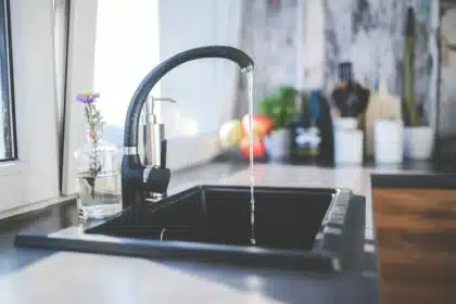 Stacked ceramic pans, silicone utensils and nested lids on a kitchen counter