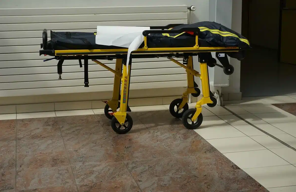 Medical staff wheeling a stretcher in a hospital corridor