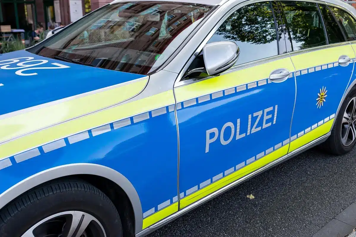 Police cruiser with flashing lights near parked car at night